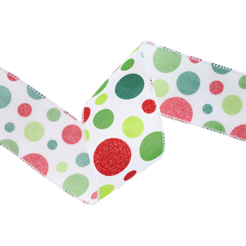 A close-up of a white ribbon with a festive multicolor polka dot pattern, featuring red, green, and light green dots on a clean white background.